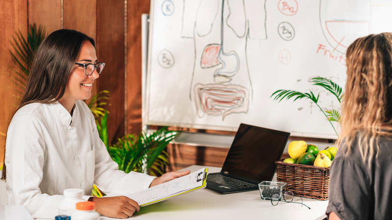 female nutritionist working with a client showing healthy food to eat