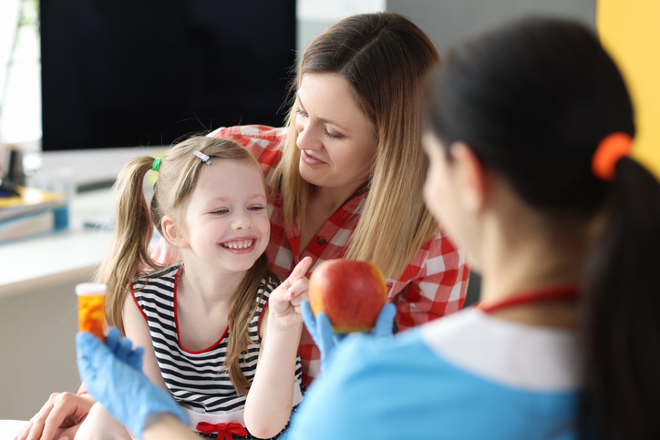 Pediatric Nutritionist offering a child some healthy food