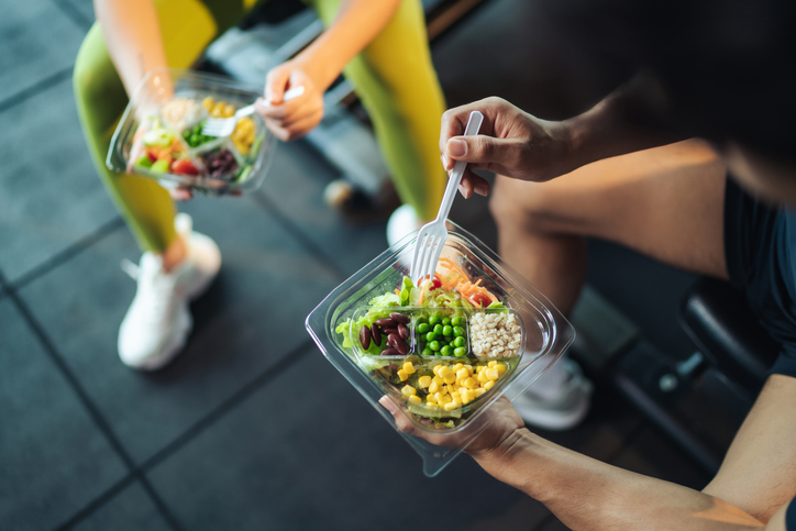 Sports Nutritionist eating food on a bench during a workout