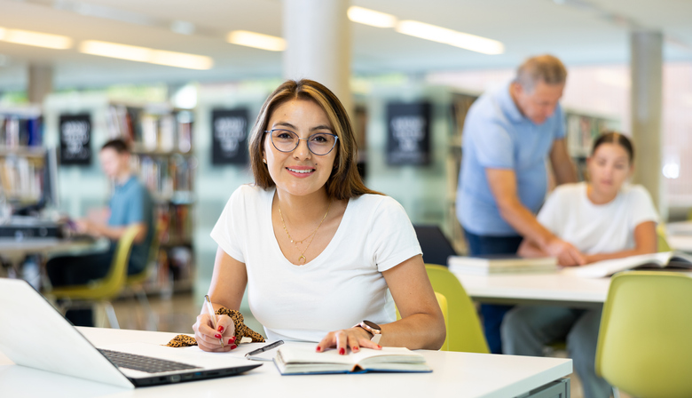 Graduate student studying in a library