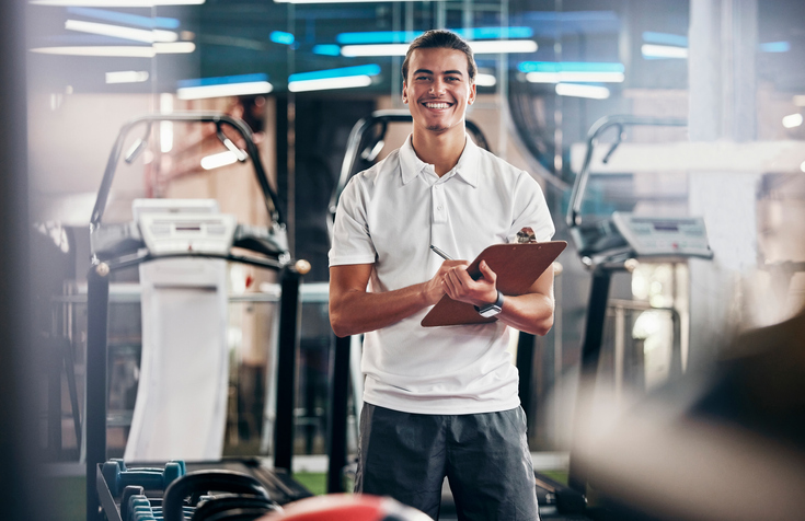 Health coach in a gym with his clipboard