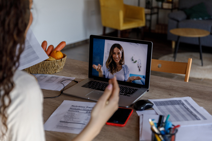 Professional female virtual nutritionist talking about nutritional facts with a client over a video conference call meeting